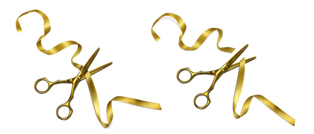 tijeras cortando una cinta dorada